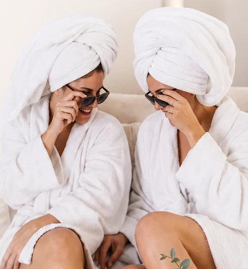 Friends in robes laughing together at an MK Wellness Spa Party